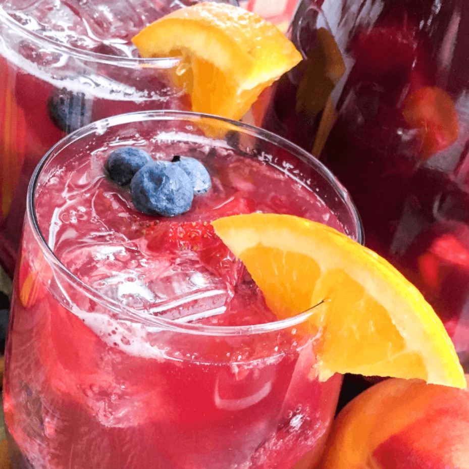 a glass of berry and peach sangria